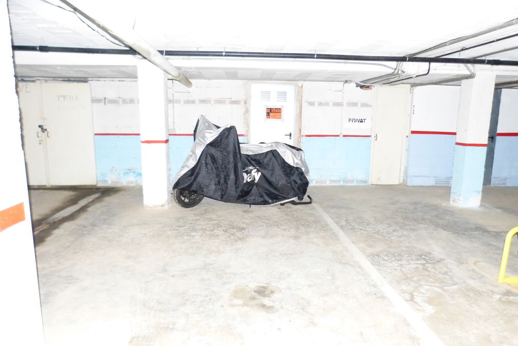 Un parking souterrain à côté de la plage avec un débarras couvert.